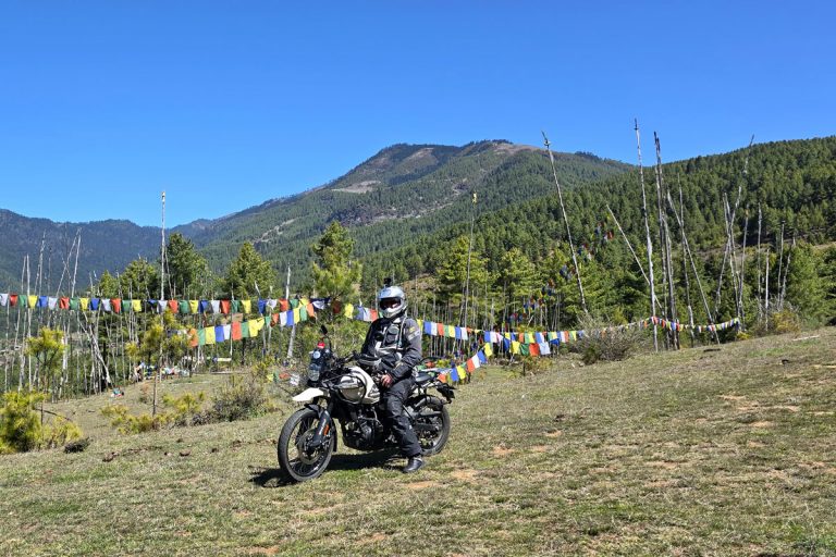 A motorbike ride through Bhutan, with prayer flags and green hills setting the scene.