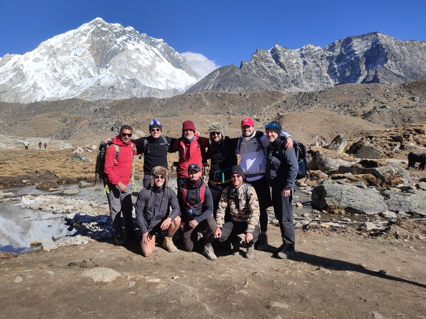 Trekkers posing at Lobuche with Mount Nutpse in the background