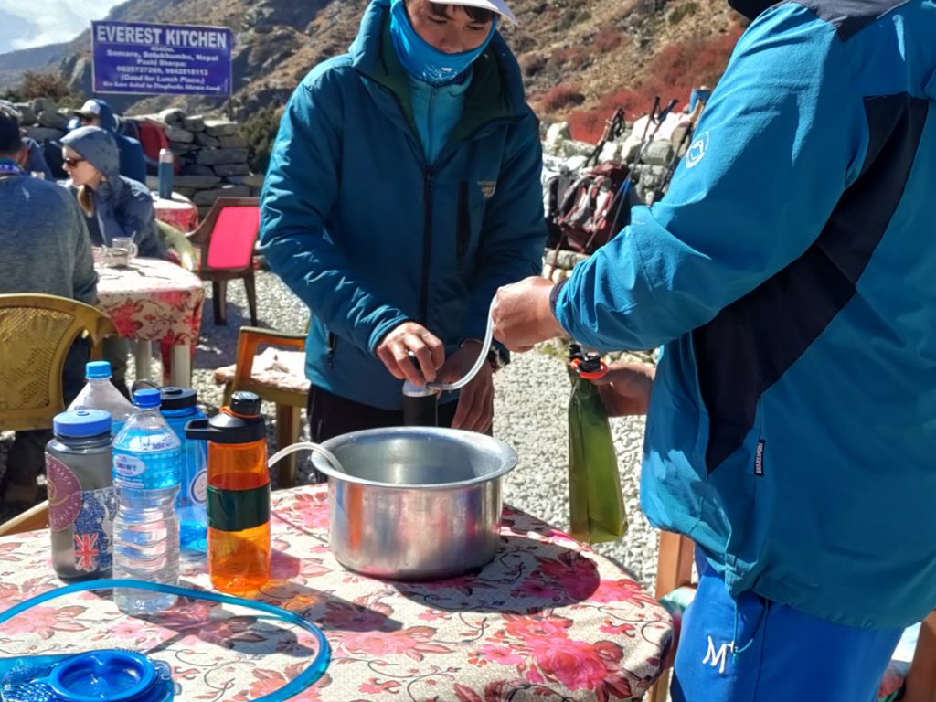 Utilizing a water filter for clean drinking water on the EBC trail.