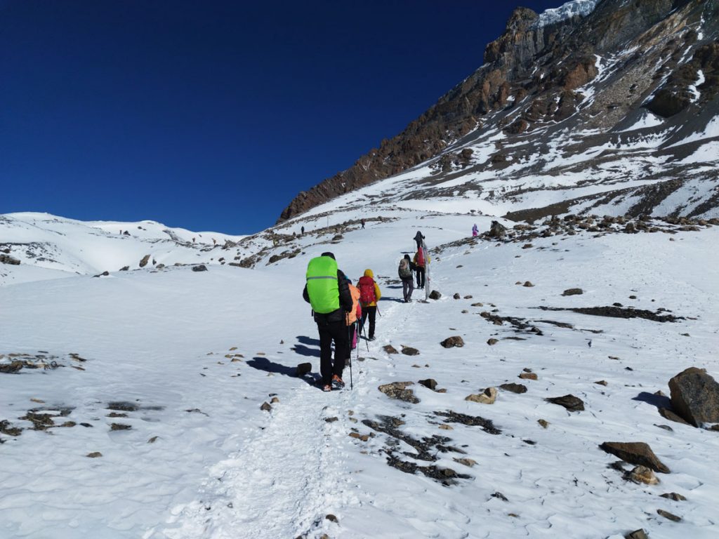 Trekkers traverse the rugged path to Thorong La Pass.