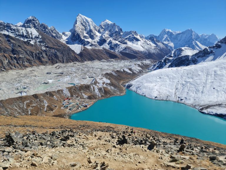 The pristine turquoise waters of Gokyo Lake, with the vast Ngozumpa Glacier in the background
