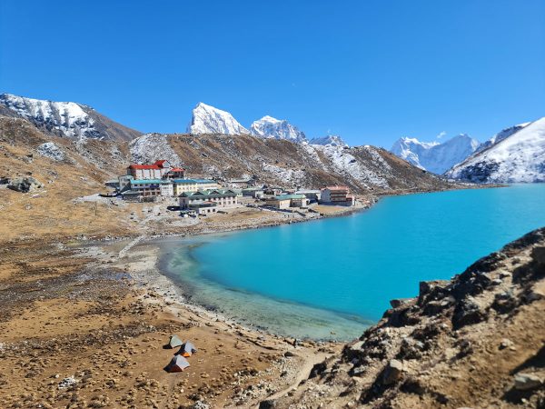 The peaceful beauty of Gokyo Lake, with its calm turquoise waters.