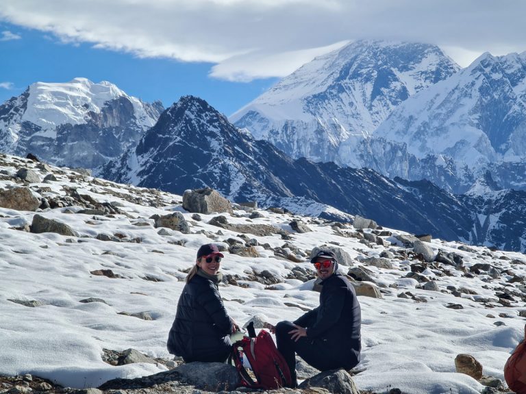 Trekkers on snowy trails enroute Renjo La Pass, with Mount Everest shrouded in clouds