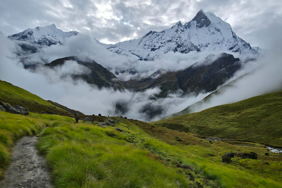 Mount Machhapuchhre emerging through drifting clouds during the monsoon season on the ABC Trek
